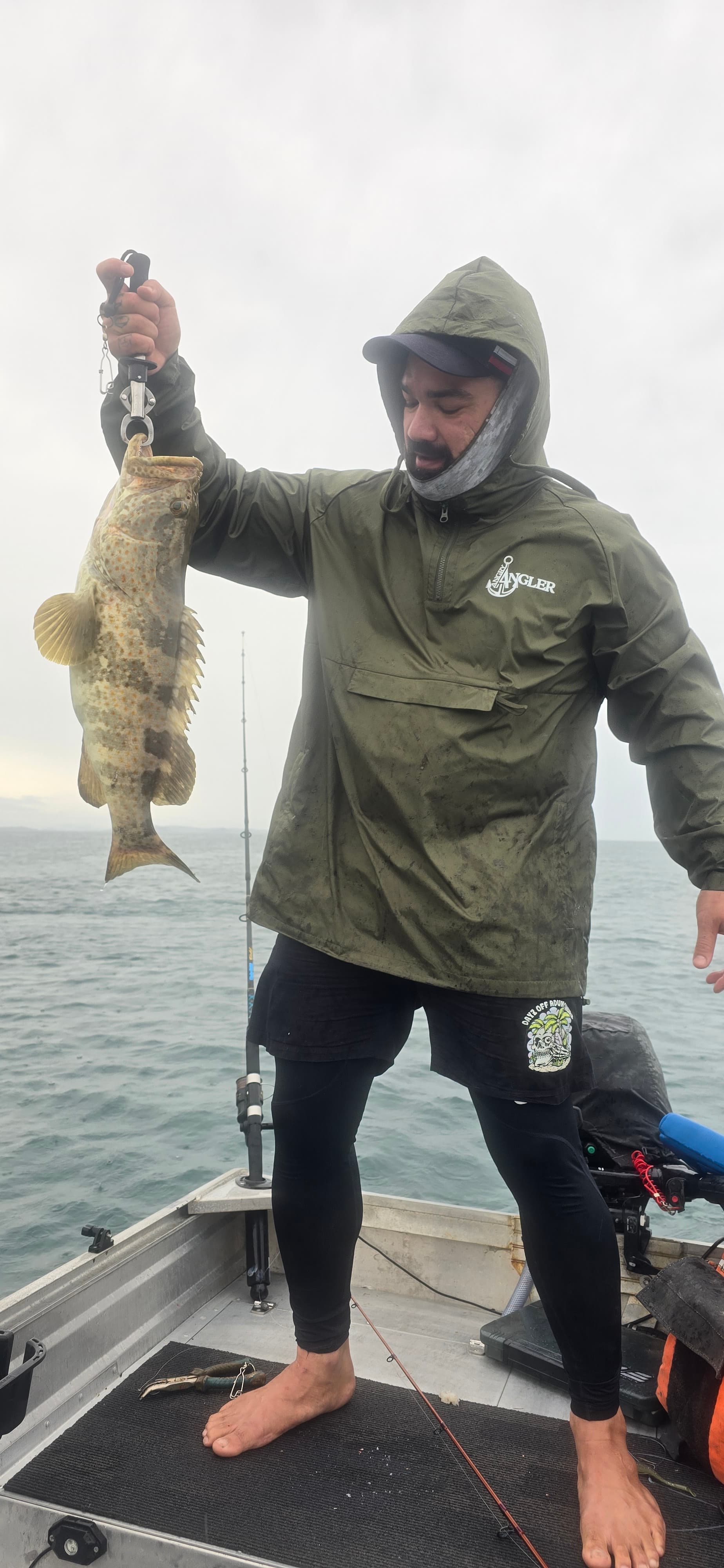 A Mackay angler holding a fish from his boat at first light
